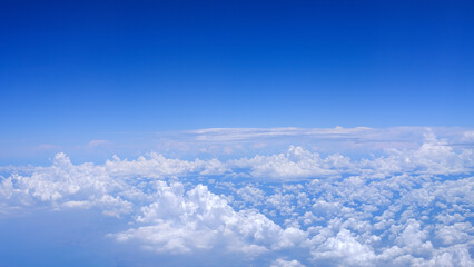 Horizontal gradient blue sky with white fluffy clouds