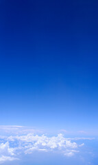 Vertical gradient blue sky with white fluffy clouds