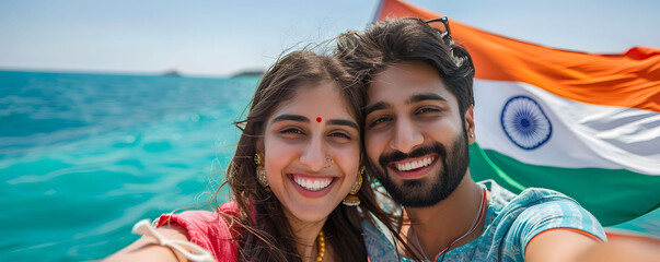 Obraz premium Smiling couple taking selfie on boat with Indian flag, enjoying vacation on turquoise blue sea.