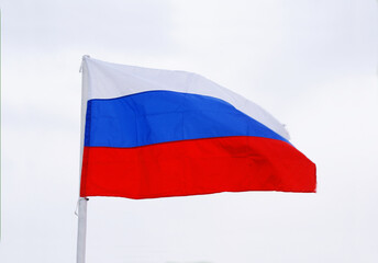The Russian flag flutters in the wind against the blue sky, Background.
