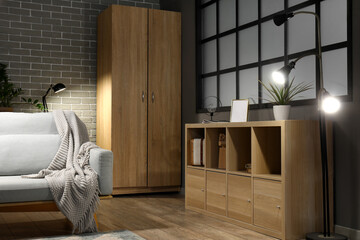 Stylish interior of living room with sofa at night