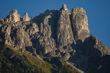 Majestic Austrian mountains with massive rocky peaks and green forested slopes, showcasing the stunning alpine landscape.