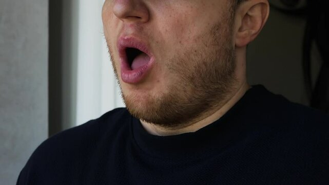 A man sneezes loudly. A young guy has a cold, a flu. Virus is a bacterial disease.
