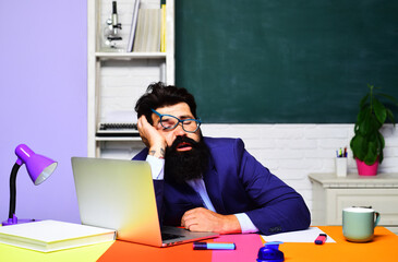 Tired teacher sleeping after lecture in classroom. School break. Fatigued male school teacher sleeping on desk. Overworked college university student preparing for exam session. Sleepy and fatigue.