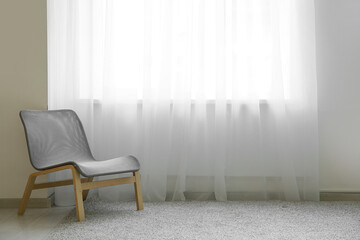 Chair and carpet near light curtain in room