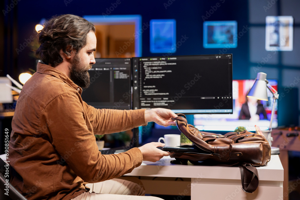 Poster programmer packing laptop at end of work shift after securing company servers from virus attacks. ma