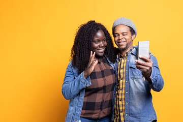 Husband and wife waving at webcam and talking to family members, using videocall conference on mobile phone network. Couple meeting with people on teleconference remote connection.