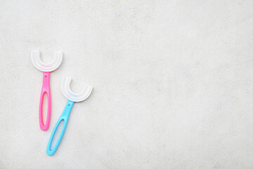 U-shaped silicone toothbrushes on light background