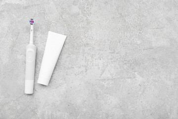 Electric toothbrush and paste on grunge background
