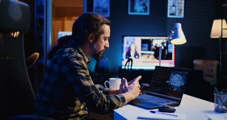 Man in home office typing on keyboard, updating artificial intelligence neural networks, writing...
