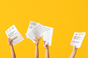 Female hands with documents and graphics on yellow background