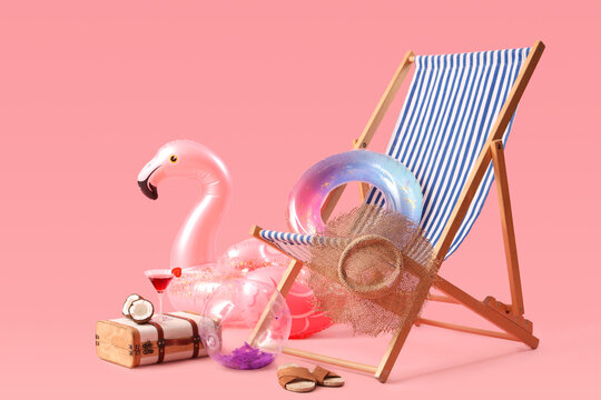 Inflatable rings, deck chair and suitcase with coconut and cocktail on pink background. Travel concept