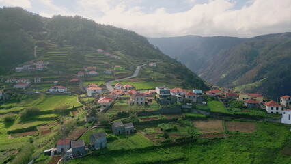 Fototapeta premium Portugal village placed mountain slopes with fields and winding roads aerial