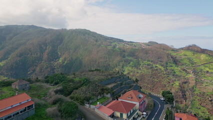Small town mountain hills covered greenery under cloudy sky aerial view. 