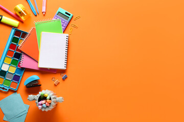 School supplies with notebooks on orange background. Top view