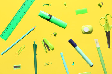 Different school stationery flying on yellow background