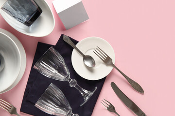Beautiful table setting with black napkin on pink background