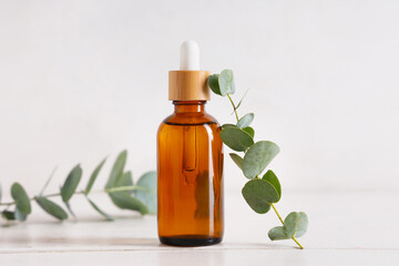 Bottle of eucalyptus essential oil on light background, closeup