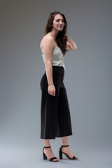 Young woman posing wearing elegant high waisted trousers and top