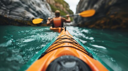 Obraz premium A kayaker is seen paddling through a striking scenic waterway, surrounded by rocky cliffs and lush nature, illustrating a peaceful yet adventurous journey through serene waters.