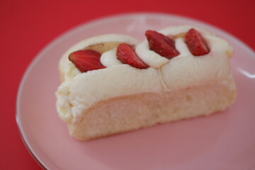 Strawberry cheese cake on red table.