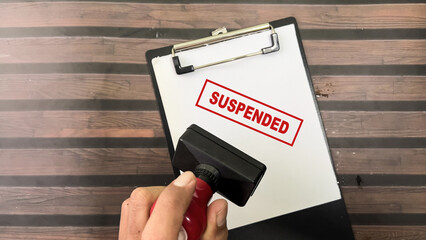 Red Handle Rubber Stamper and Suspended text above paperwork isolated on wooden background