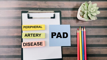 Concept of PAD - Peripheral Artery Disease write on sticky notes isolated on Wooden Table.