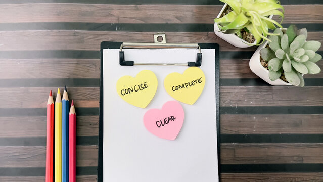 Concept of Concise, Clear, Complete write on sticky notes isolated on Wooden Table.
