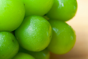Close up of shining muscat grapes on wooden table background. Healthy food concept.