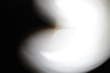 Una toma de cerca de una luz de una lampara en forma líneas de color blanco en movimiento en la oscuridad. Movimiento de cámara