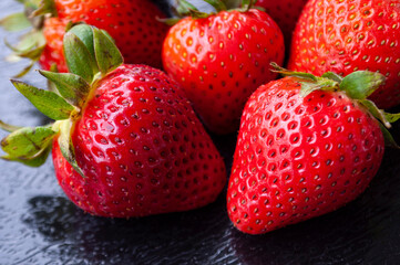 Close up of strawberries on black cover background. Healthy food and fruits concept