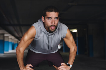Tired, breathe and man with break in exercise for sports training, fatigue and workout recovery....