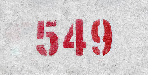 Red Number 549 on the white wall. Spray paint.