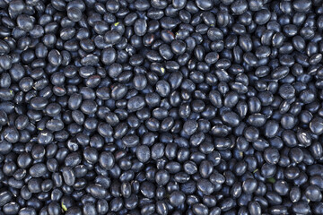 Close up and top angle view of stacked dried black bean with seeds for sale in a traditional market, South Korea
