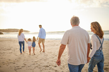 People, family and generations with walking in beach for bonding, break and holiday in Bali. Parents, grandparents and kids in ocean on sunset for vacation, adventure and journey to relax and fun