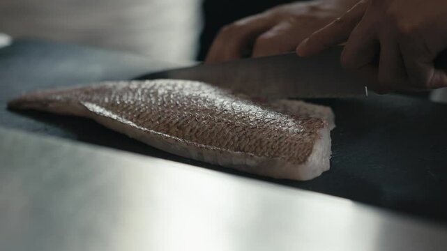 包丁で鯛・魚の切り身を捌く料理人の手元　料理・日本・和食・シェフ・シーフード