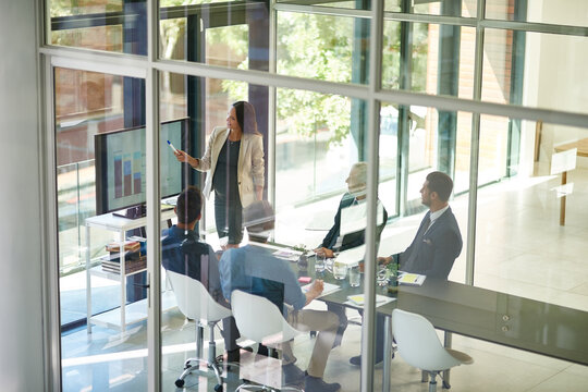 Business woman, talking and conference room glass with collaboration and digital chart. Speaker, above and accounting data with workshop and presenter in office with company stats review meeting - Powered by Adobe