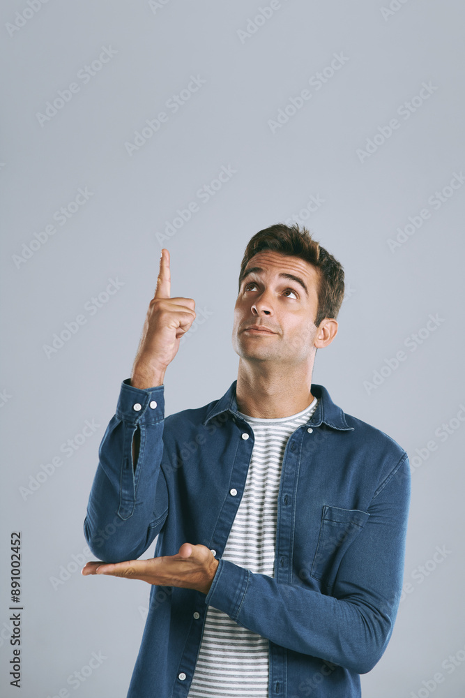 Poster man, studio and pointing up at mockup for idea, opinion and choice on gray background. male designer