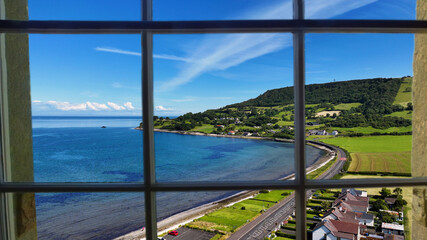 Looking through a window of the beautiful Glencloy on the Irish Sea Antrim Northern Ireland on a sunny day with a blue sky