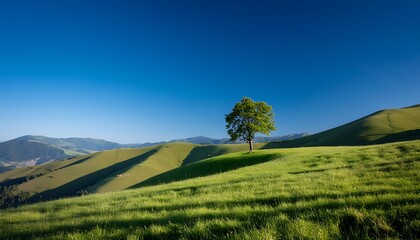 Fototapeta premium A scenic summer landscape with rolling green hills, a farmhouse nestled amongst trees, and fluffy clouds drifting across a blue sky