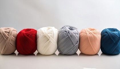 Colorful spools of yarn in various colors sit isolated on a white background