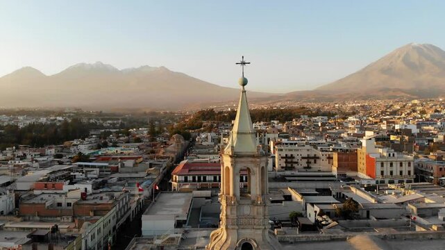 Torre de la Catedral de Arequipa con vista al volc&aacute;n misti y chachani en el atardecer.
