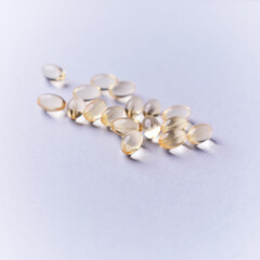 Vitamin E capsules. Antioxidants. Concept for a healthy dietary supplementation. Bright paper background. Soft focus. Close up. Copy space.	