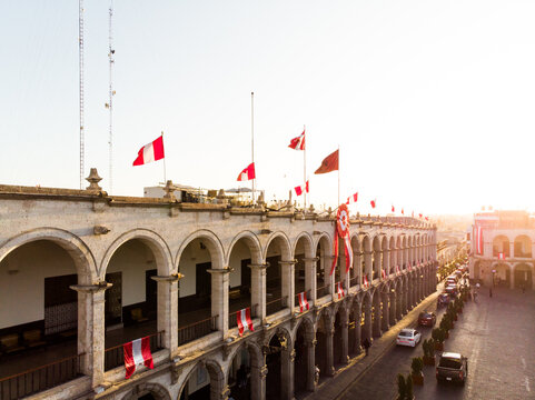 Portales de la plaza principal de Arequipa en el atardecer con las banderas del Per&uacute; en el mes de Julio 
