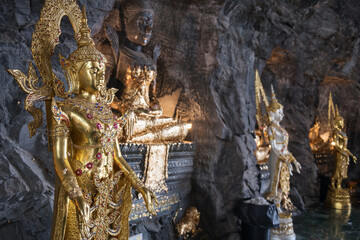 Golden Buddha statue and god inside Suphan buri cave tunnel