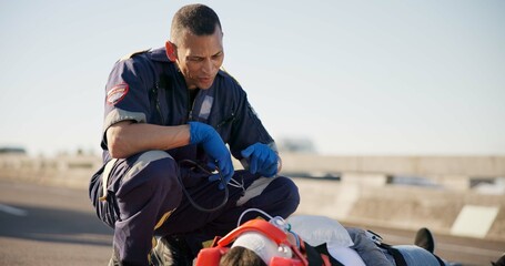 Paramedic, emergency and talking on road from car crash accident with healthcare, EMT man and first aid. Patient, ambulance staff and medical help with rescue on stretcher for transport to clinic © CineLens2024/peopleimages.com