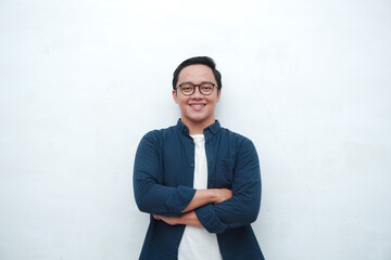 Handsome Asian man with crossed arm smiling to camera. Concept of student or business man. 