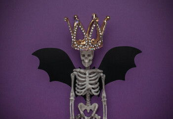 Skeleton with Crown and Bat Wings on Purple Background