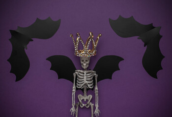 Halloween Skeleton with Crown and Bat Wings on Purple Background