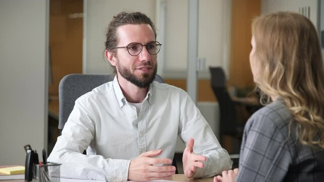 Businessman interviewing an applicant at his office. Two professional having a question and answer conversation in a modern office.